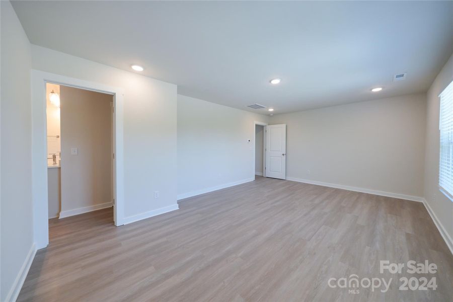 Primary Bedroom up is spacious featuring EVP flooring and ample natural lighting