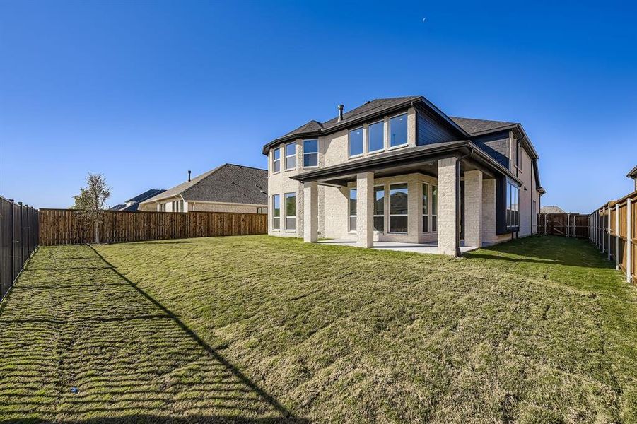 Back of property with a fenced backyard, a patio area, and brick siding