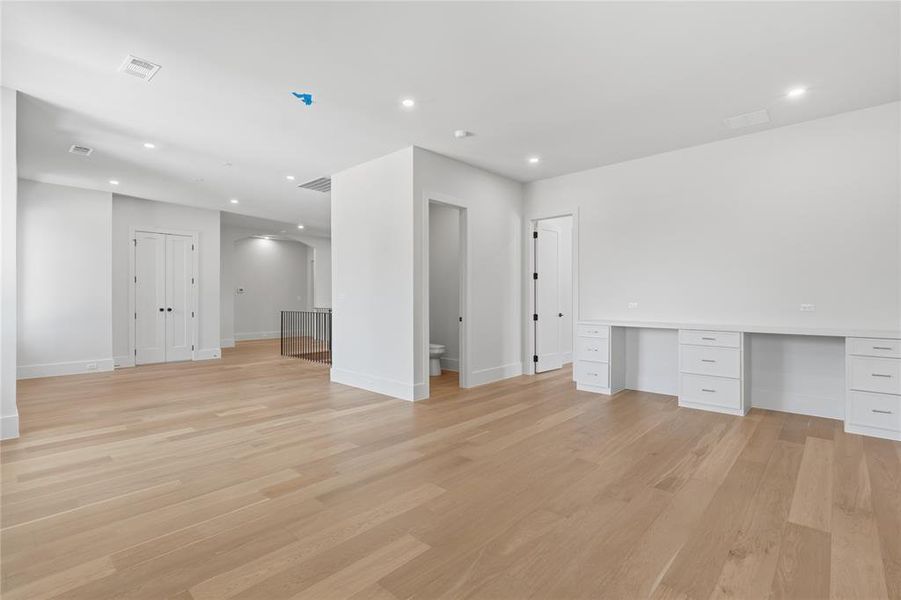 Game room with built-in desk, recessed lighting, and open access to secondary bedrooms Game room with built-in desk, recessed lighting, and open access to secondary bedrooms