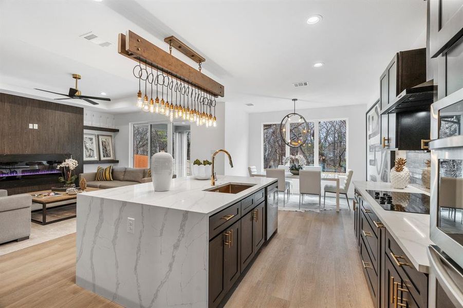 Kitchen featuring sink, light stone countertops, light wood-type flooring, and appliances with stainless steel finishes