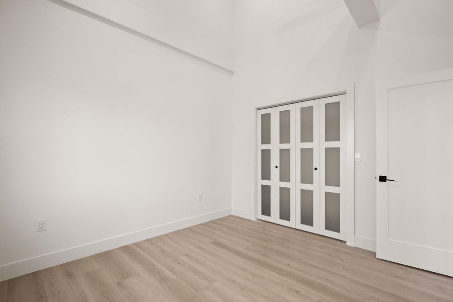 Spare room with light wood finished floors and a high ceiling