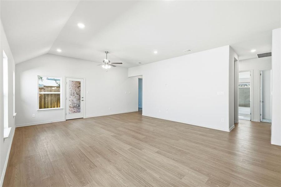 Unfurnished living room featuring light wood-type flooring, recessed lighting, ceiling fan, and vaulted ceiling