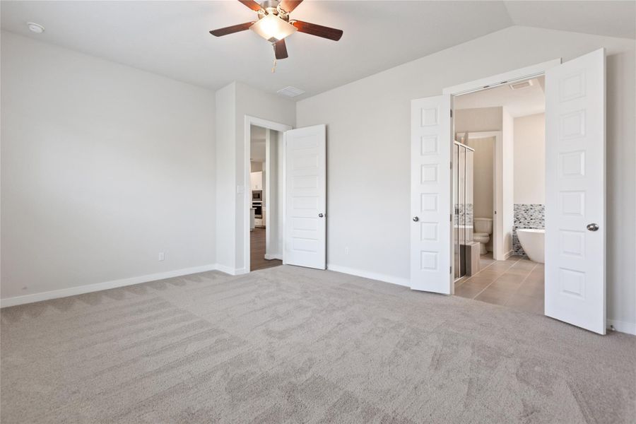 Unfurnished bedroom featuring light carpet, ceiling fan, ensuite bath, and light tile patterned flooring