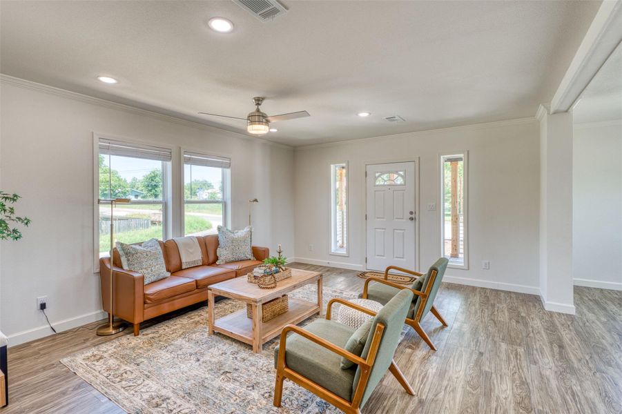 A welcoming living room featuring laminate wood style flooring and ample natural light. A welcoming living room featuring laminate wood style flooring and ample natural light.