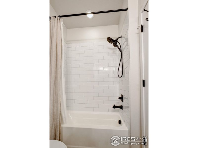 Guest tub/shower with full tile surround and upgraded shower head