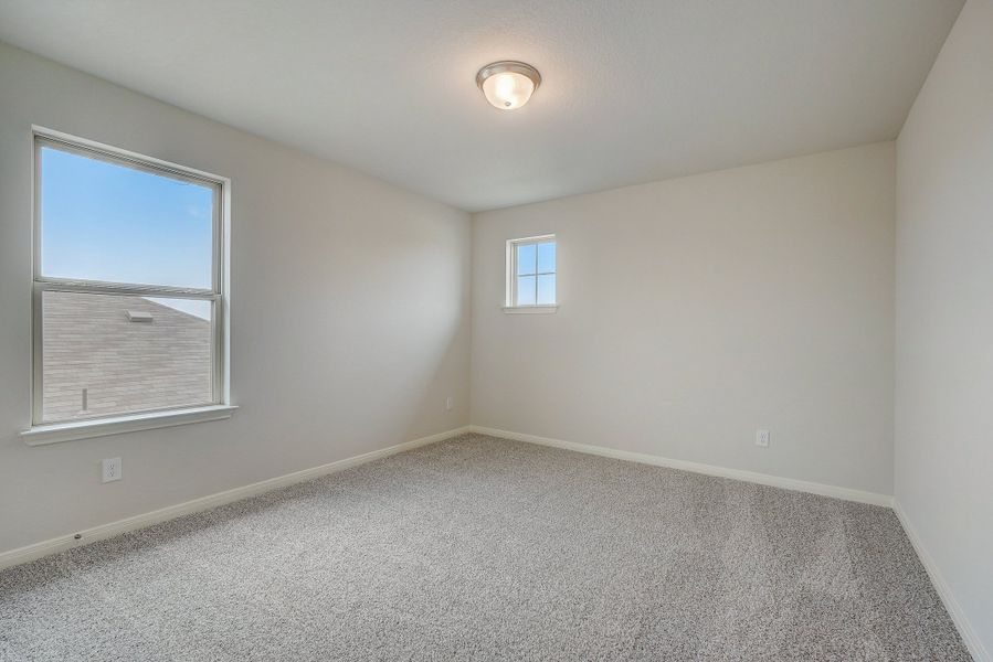 Guest bedroom in the Pearl floorplan at a Meritage Homes community.