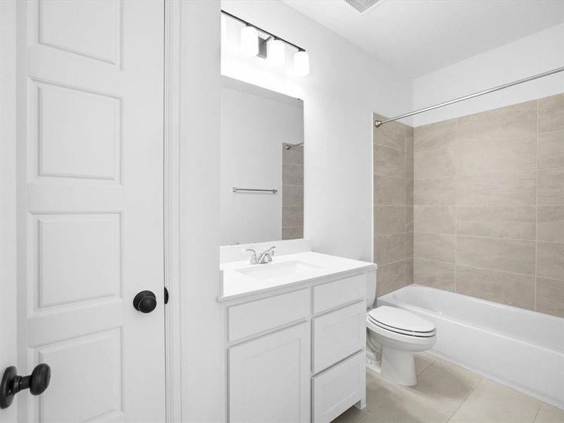 Bathroom featuring vanity, bathtub / shower combination, and light tile patterned floors Bathroom featuring vanity, bathtub / shower combination, and light tile patterned floors