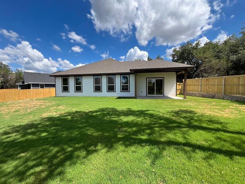 Rear view of property with a lawn