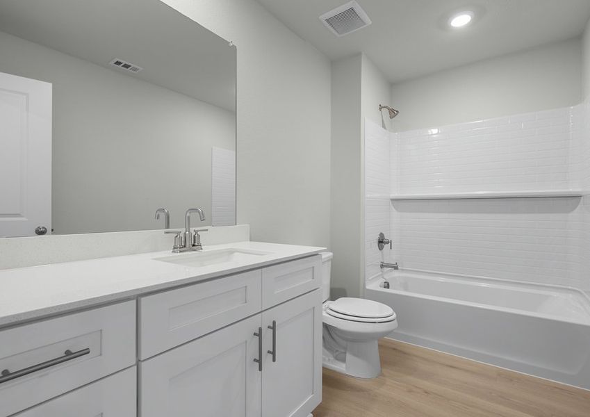 Beautiful secondary bath with white cabinet vanity and shower/tub combo.