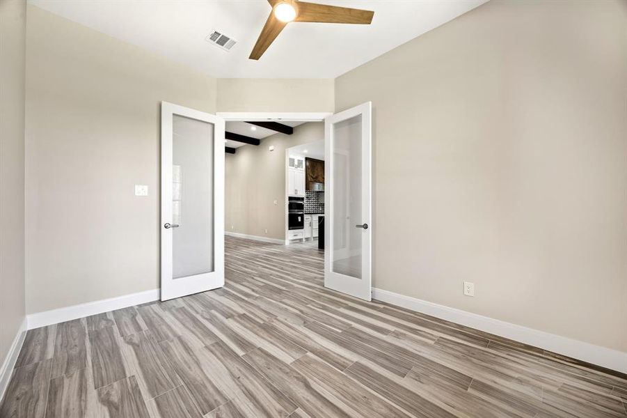 Unfurnished room featuring ceiling fan, light hardwood / wood-style flooring, and french doors