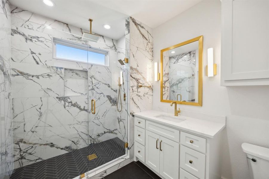Bathroom with toilet, recessed lighting, vanity, and a marble finish shower Bathroom with toilet, recessed lighting, vanity, and a marble finish shower