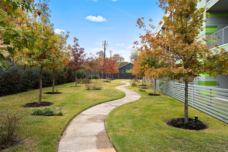 View of property's community with fence private yard and a yard