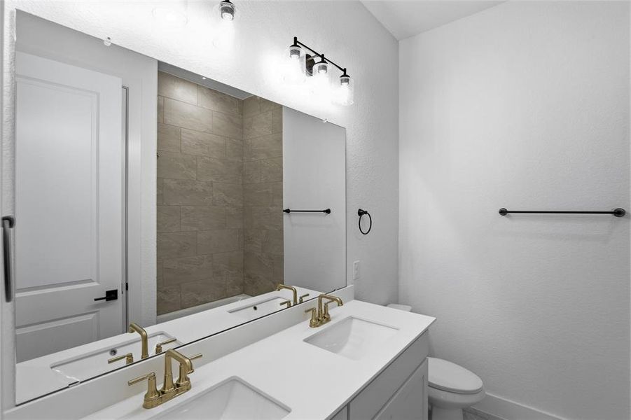Full bathroom featuring double vanity and toilet