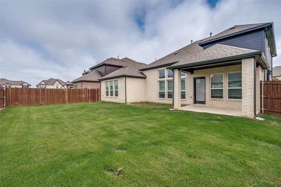 Rear view of property with a patio, roof with shingles, and brick siding Rear view of property with a patio, roof with shingles, and brick siding