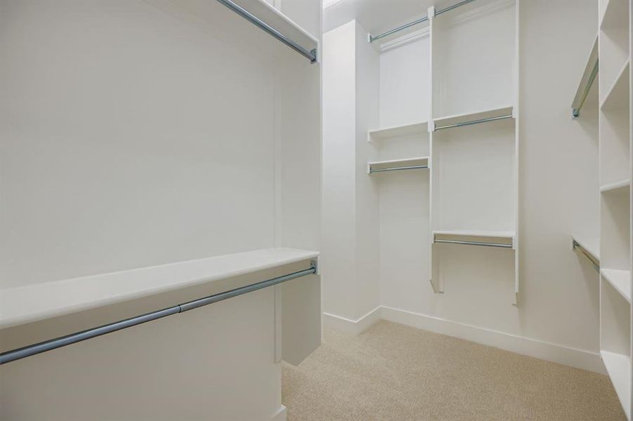 Spacious closet with light colored carpet Spacious closet with light colored carpet