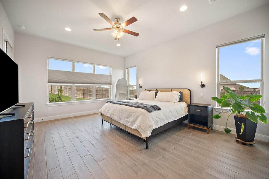Bedroom with light wood-style flooring, recessed lighting, multiple windows, and a ceiling fan