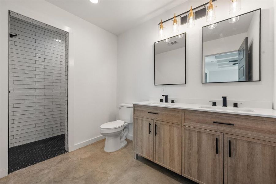 Full bath with double vanity, walk in shower, and recessed lighting