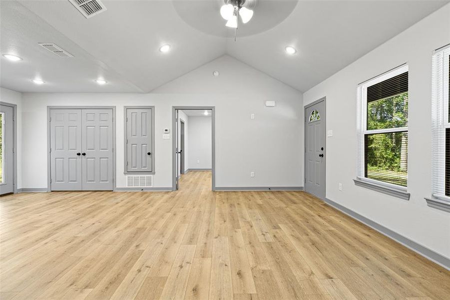 Unfurnished living room featuring vaulted ceiling, a ceiling fan, light wood-style flooring, and recessed lighting Unfurnished living room featuring vaulted ceiling, a ceiling fan, light wood-style flooring, and recessed lighting