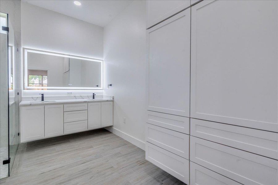 Bathroom with double vanity, wood finished floors, recessed lighting, and walk in shower Bathroom with double vanity, wood finished floors, recessed lighting, and walk in shower