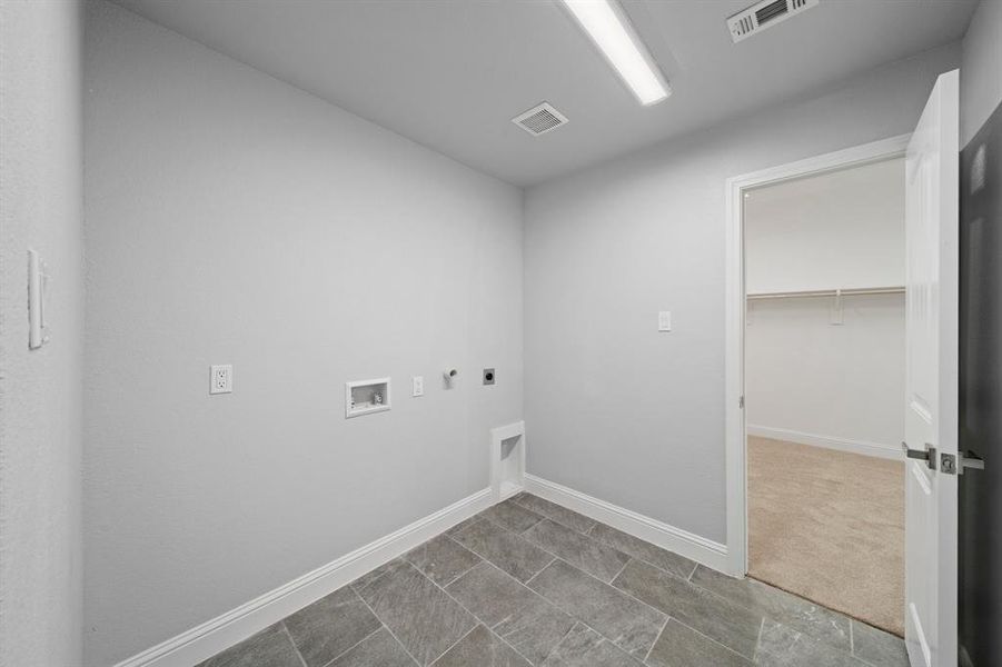 Laundry room featuring gas dryer hookup, tile patterned floors, hookup for an electric dryer, and washer hookup