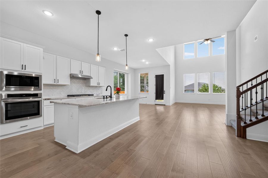 An open concept design seamlessly connects the modern kitchen to the soaring living area. An open concept design seamlessly connects the modern kitchen to the soaring living area.