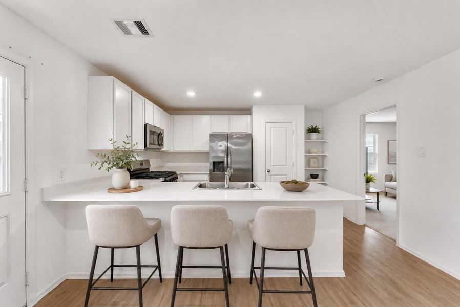 The kitchen island provides ample seating (Furniture has been virtually staged)