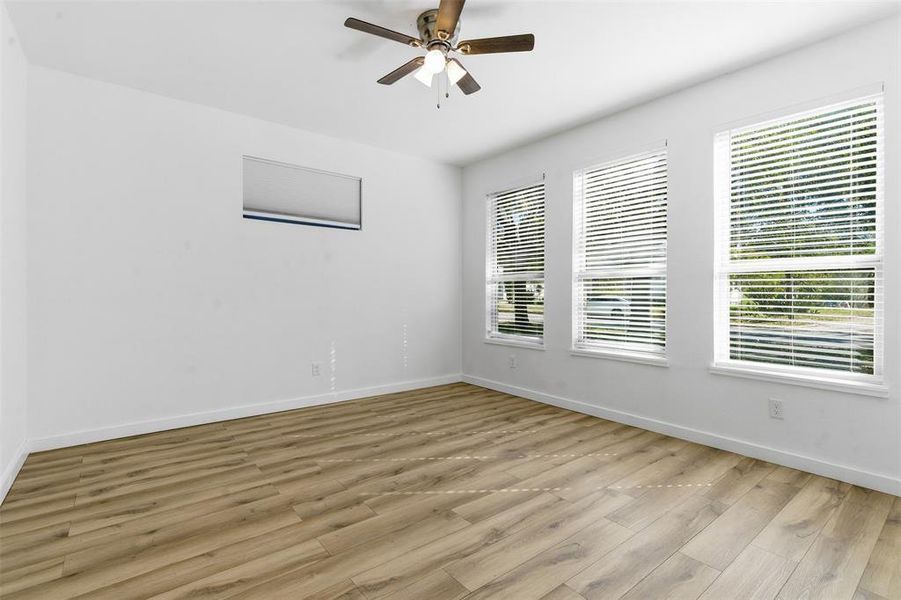 Spare room with healthy amount of natural light, wood finished floors, and a ceiling fan Spare room with healthy amount of natural light, wood finished floors, and a ceiling fan