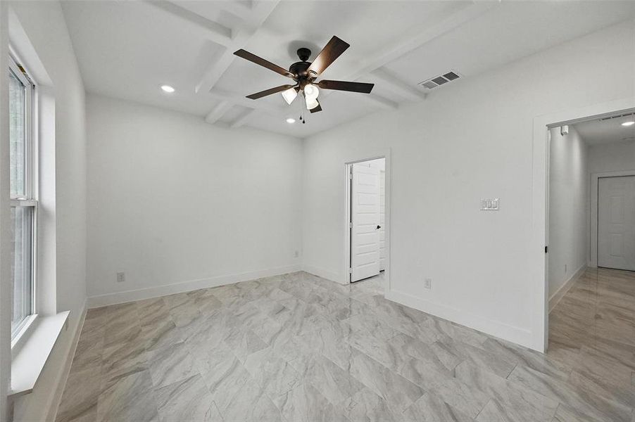 Unfurnished room featuring recessed lighting, ceiling fan, beamed ceiling, coffered ceiling, and healthy amount of natural light