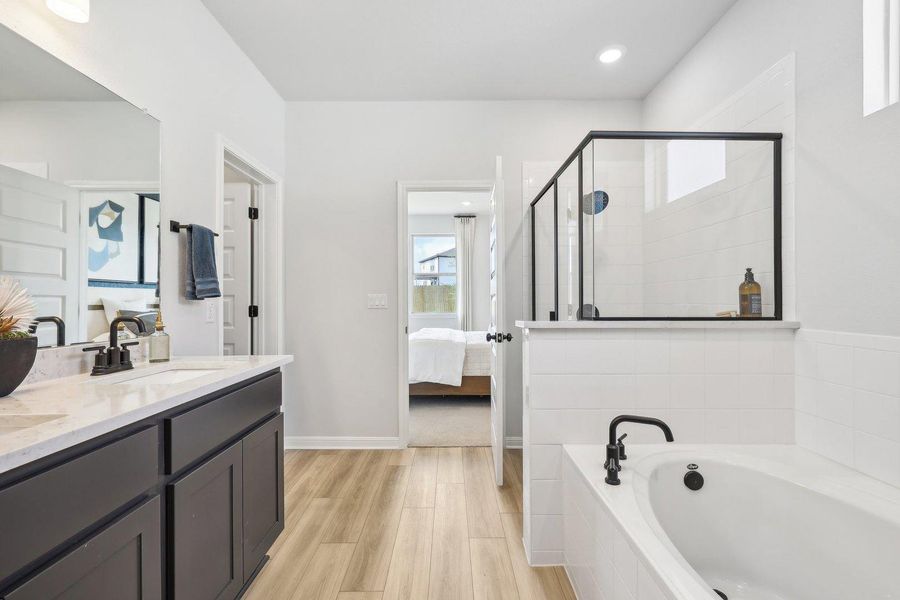 Luxurious primary bath with a spacious soaking tub, double vanity, and a sleek, modern shower enclosure. Luxurious primary bath with a spacious soaking tub, double vanity, and a sleek, modern shower enclosure.