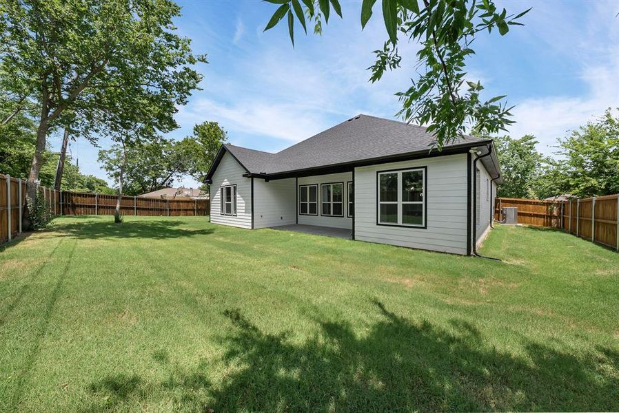 Rear view of property featuring a fenced backyard and roof with shingles Rear view of property featuring a fenced backyard and roof with shingles