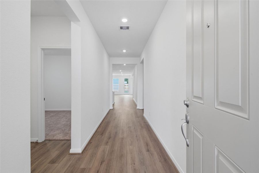 Step inside your new home, where the Layton Lake vinyl plank flooring in Wild Dunes and fresh, bright paint create a warm and inviting entryway.