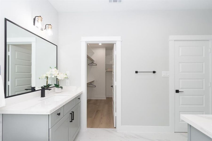 A spacious walk-in closet awaits, complete with built-in shelves and hanging space. Organization becomes effortless, allowing you to keep your wardrobe tidy and accessible.