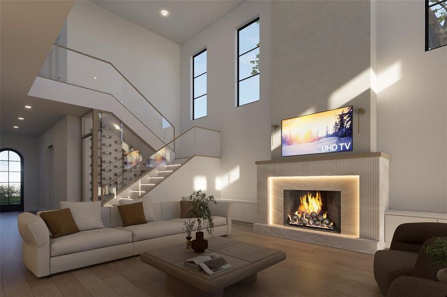 Living room featuring a warm lit fireplace, wood finished floors, a high ceiling, and recessed lighting
