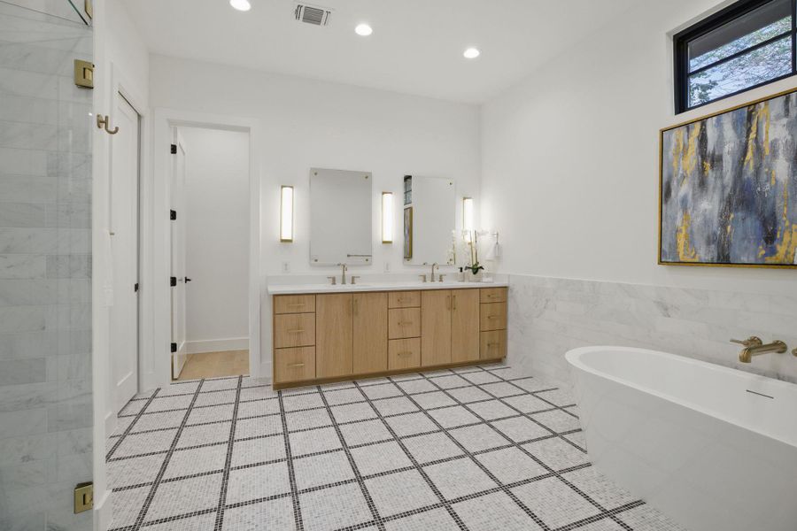 Bathroom featuring a freestanding bath, double vanity, tile walls, recessed lighting, and tile patterned flooring