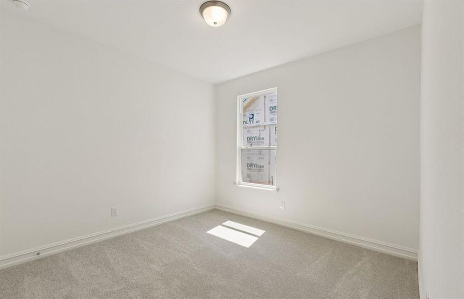 Comfortable secondary bedroom with generous closet space  *Real home pictured