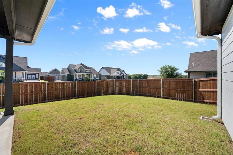 Privacy Fenced backyard with secure entry gates with side door access to the garage.