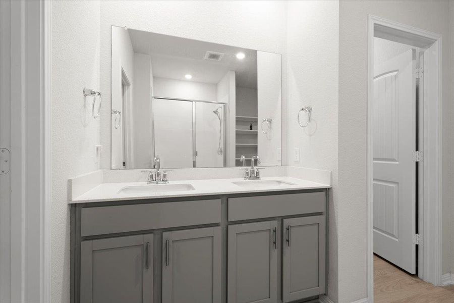 Dual basin vanity with grey shaker-style cabinetry, white countertops, and chrome fixtures