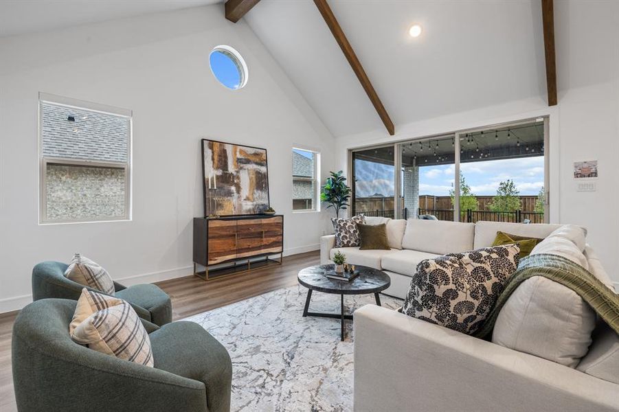 Living room featuring wood finished floors, beam ceiling, high vaulted ceiling, and recessed lighting