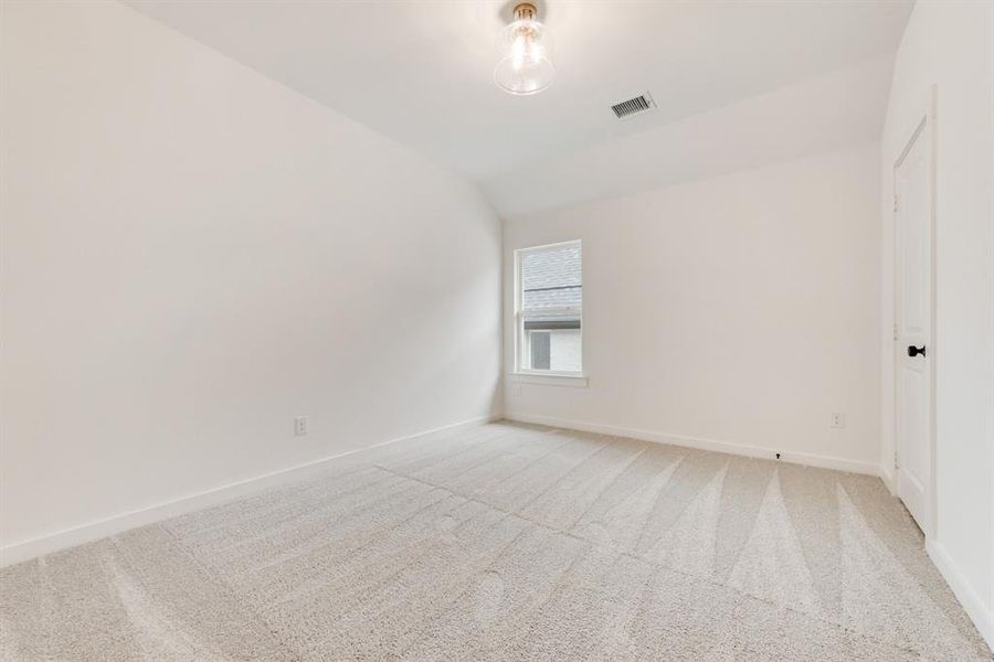 Unfurnished room with carpet floors and vaulted ceiling Unfurnished room with carpet floors and vaulted ceiling