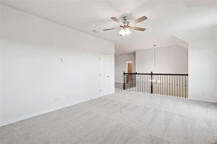 Empty room featuring carpet flooring, ceiling fan, and lofted ceiling