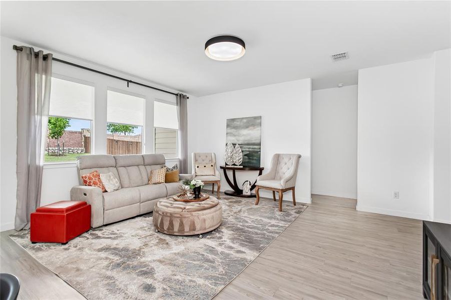 The property features an open-concept living area with light-toned flooring, white walls, and recessed lighting