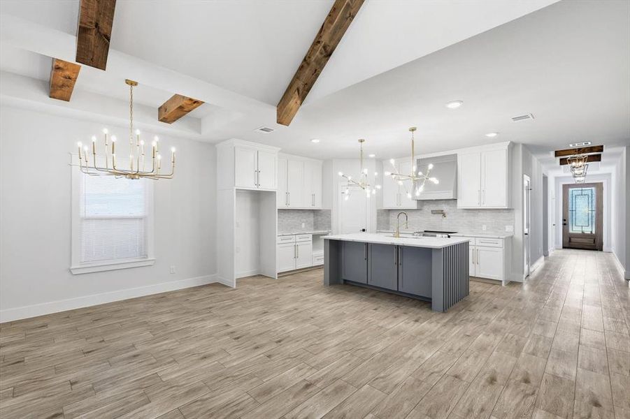 Kitchen with a chandelier, gray cabinets, white cabinets, plenty of natural light, and beam ceiling