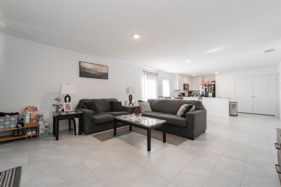 Living area with recessed lighting and light tile patterned flooring