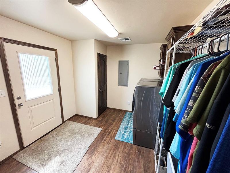 Laundry area with washer / clothes dryer, dark wood finished floors, and electric panel Laundry area with washer / clothes dryer, dark wood finished floors, and electric panel