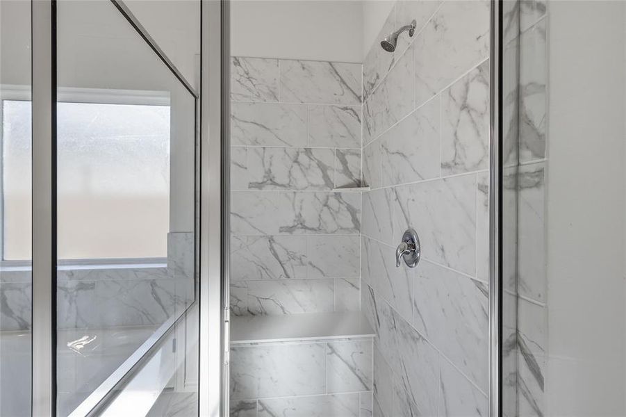 Bathroom featuring a marble finish shower and a tub with marble appearance Bathroom featuring a marble finish shower and a tub with marble appearance