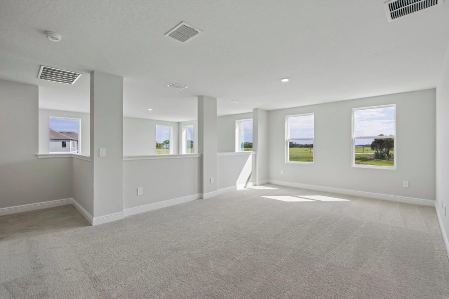 As you reach upstairs you are welcomed into the large open bonus room that looks out on to the two-story family room