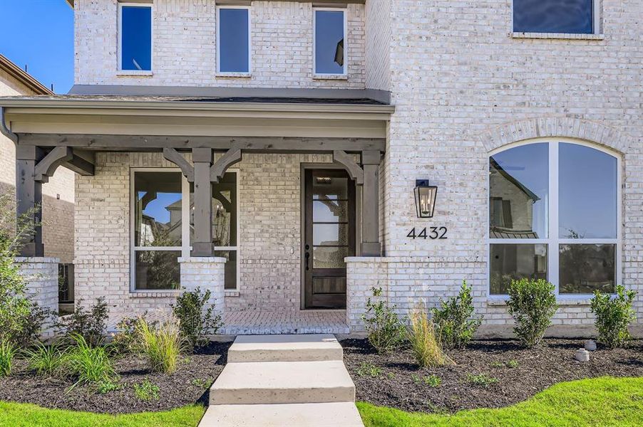 Property entrance featuring covered porch and brick siding Property entrance featuring covered porch and brick siding