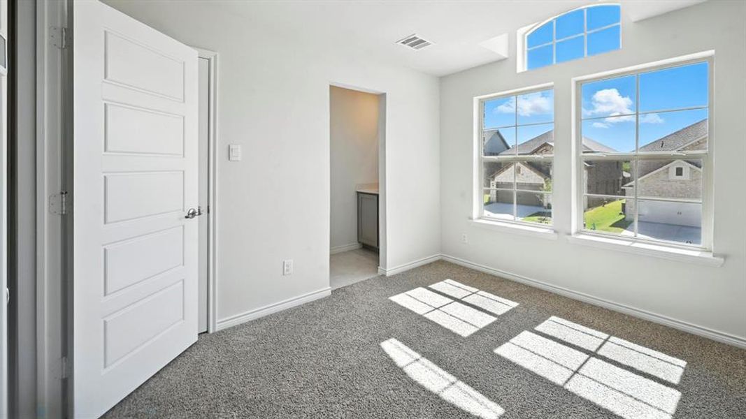 Unfurnished bedroom featuring ensuite bath and carpet flooring Unfurnished bedroom featuring ensuite bath and carpet flooring