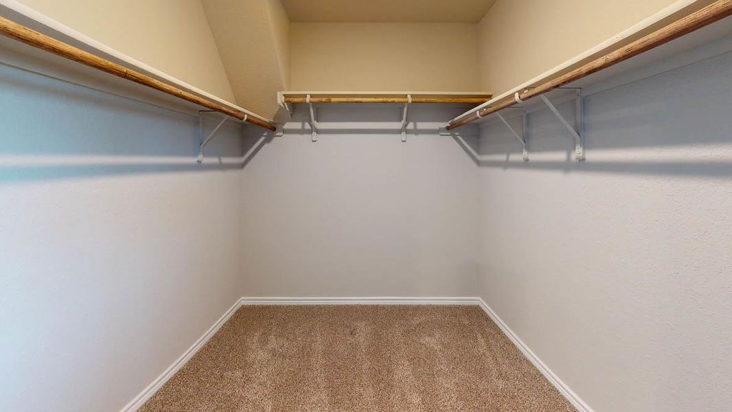 Walk in closet featuring light colored carpet Walk in closet featuring light colored carpet