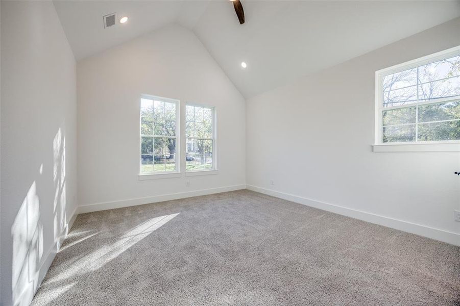 Unfurnished room with carpet flooring and lofted ceiling